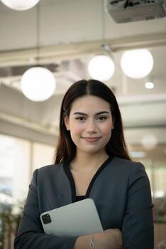 portrait of business female rookie in the new entrepreneurial with a tablet as a tool to help in the work photo